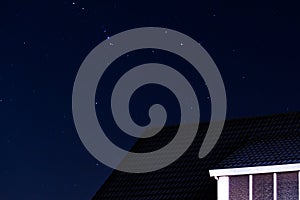 Pointy house rooftop with a sky full of stars at night photo