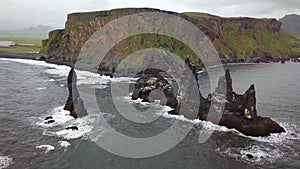 Pointy rocks sticking out of the ocean at Reynisfjara Beach near Vik in Iceland