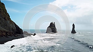 Pointy rocks sticking out of the ocean at Reynisfjara Beach near Vik in Iceland