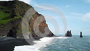 Pointy rocks sticking out of the ocean at Reynisfjara Beach near Vik in Iceland