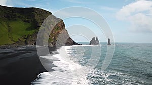 Pointy rocks sticking out of the ocean at Reynisfjara Beach near Vik in Iceland