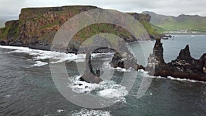 Pointy rocks sticking out of the ocean at Reynisfjara Beach near Vik in Iceland