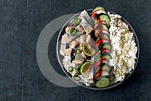 Poke a bowl of herring fillet, vegetables and rice.