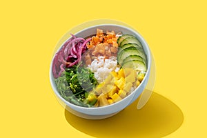 Poke bowl with rice, salmon,cucumber,mango,onion,wakame salad, poppy seeds ands sunflowers seeds