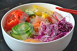 Poke bowls with fresh salmon, crystal noodles, radish, avocado, sweet pepper, cucumber, sesame seeds, red cabbage.