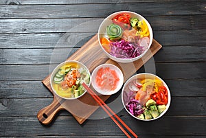 Poke bowls with fresh salmon, crystal noodles, radish, avocado, sweet pepper, cucumber, sesame seeds, red cabbage