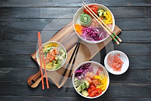 Poke bowls with fresh salmon, crystal noodles, radish, avocado, sweet pepper, cucumber, sesame seeds, red cabbage.