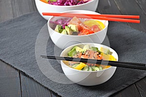 Poke bowls with fresh salmon, crystal noodles, radish, avocado, sweet pepper, cucumber, sesame seeds, red cabbage