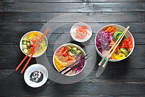 Poke bowls with fresh salmon, crystal noodles, radish, avocado, sweet pepper, cucumber, sesame seeds, red cabbage