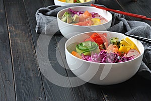 Poke bowls with fresh salmon, crystal noodles, radish, avocado, sweet pepper, cucumber, sesame seeds, red cabbage