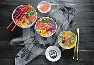 Poke bowls with fresh salmon, crystal noodles, radish, avocado, sweet pepper, cucumber, sesame seeds, red cabbage.