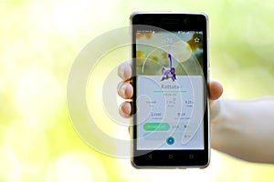 Pokemon Go game in a hand. Rattata