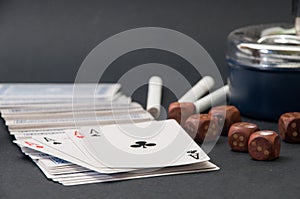 Poker of aces and wooden dice with a ashtray and cigarettes on a