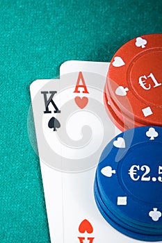 Poker cards and gambling chips on green table