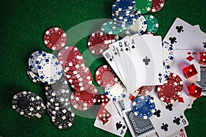 Poker chips and cards on casino gamble green table with royal fl