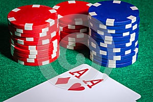 Poker chips and cards with two aces at the poker table