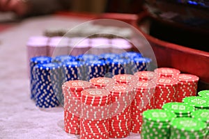 Poker chips colorful gaming pieces lie on the game table in the stack