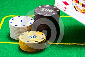 Poker chips and falling on green canvas playing cards
