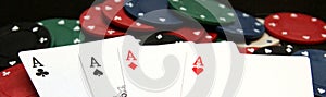 Poker chips and four aces on laptop