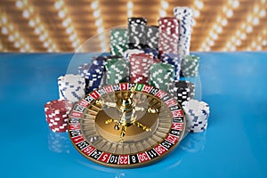 Poker Chips on gaming table, roulette wheel in motion, casino background