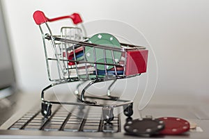 Poker chips in a shopping cart on a computer. Online Gambling addiction concept