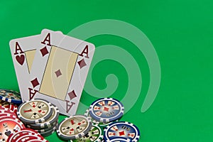 Poker chips stack and playing cards - two aces on green table