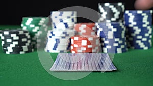 Poker game with a pair of fives betting all the poker chips. Close-up of a gambler hand is holding playing cards in