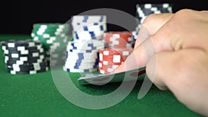 Poker game with a pair of sevens betting all the poker chips. Close-up of a gambler hand is holding playing cards in