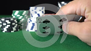 Poker game with a pair of sixes betting all the poker chips. Close-up of a gambler hand is holding playing cards in