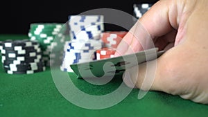 Poker game with a pair of treys betting all the poker chips. Close-up of a gambler hand is holding playing cards in