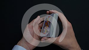 Poker game - shuffling cards. Man`s hands shuffing cards. Close up. Man`s hands shuffling playing cards. Dealer`s hands