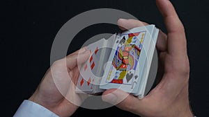 Poker game - shuffling cards. Man`s hands shuffing cards. Close up. Man`s hands shuffling playing cards. Dealer`s hands