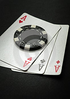 Poker game with three of a kind or set combination. Chip and playing cards on a black table in a poker club