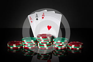 Poker game with three of kind or set combination. Chips and cards on black table. Successful and win three aces