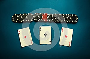 Poker game with a winning combination of three of a kind or set. Playing cards and chips on a blue table in a poker club