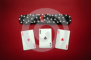 Poker game with a winning combination of three of a kind or set. Playing cards and chips on a red table in a poker club. Winning