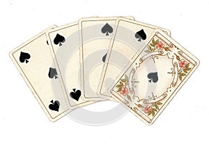 A poker hand of antique playing cards showing a straight flush of spades.