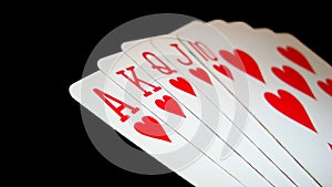 Poker hand of Royal Flush of hearts isolated on black background.