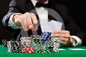 Poker player with cards and chips at casino