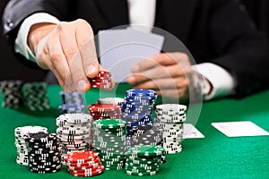 Poker player with cards and chips at casino