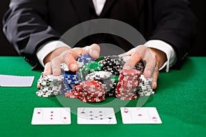 Poker player with cards and chips at casino