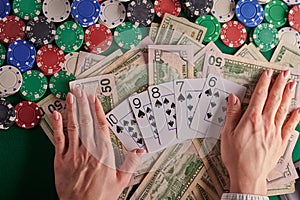 A poker player in a casino, a combination of straight flush cards, a lot of money and chips. horizontal frame. casino background