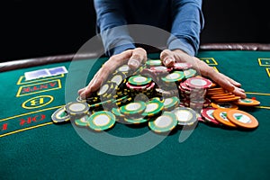 Poker player going all in pushing his chips forward