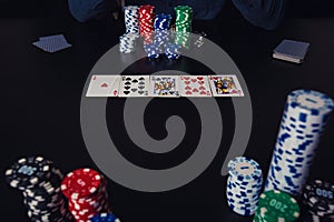 Poker player seated at the casino table thinking and betting chips. Gambling tournament winner success concept