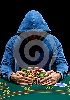 Poker player taking poker chips after winning