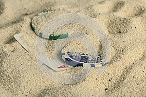 Poker playing cards buried in a sand dune