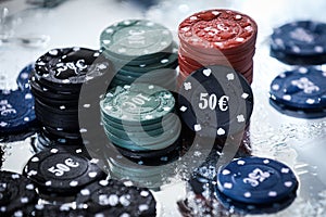 Poker playing chips on a green table and black background. Online gambling. Addiction. Casino play