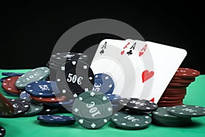 Poker playing chips on a green table and black background. Online gambling. Addiction. Falling poker chips