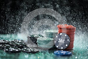 Poker playing chips on a green table and black background under the water drops. Online gambling.
