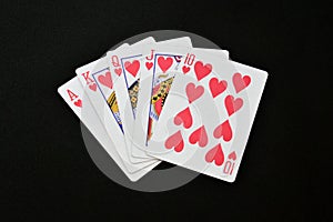 poker royal flush hearts , isolated black background